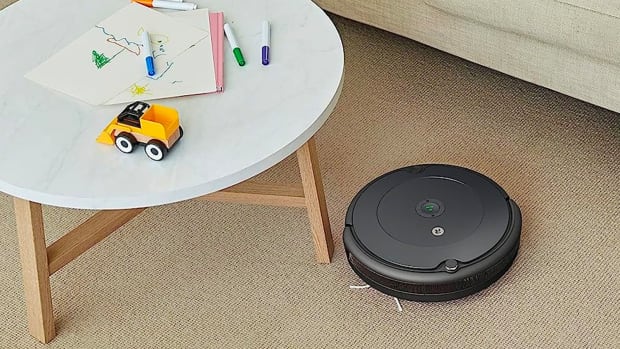 the irobot roomba 694 vacuuming a living room around a coffee table
