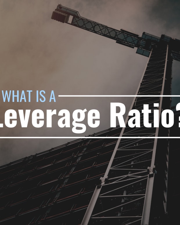 Darkened photo of a crane and a building under construction with text overlay that reads "What Is a Leverage Ratio?"