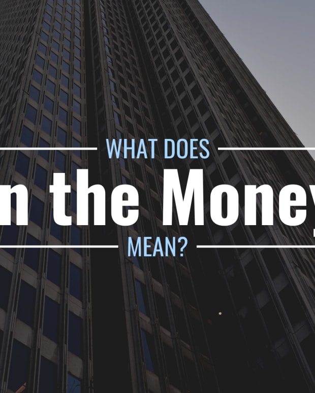 Darkened photo of high-rise office building with text overlay that reads "What Does in the Money Mean?"