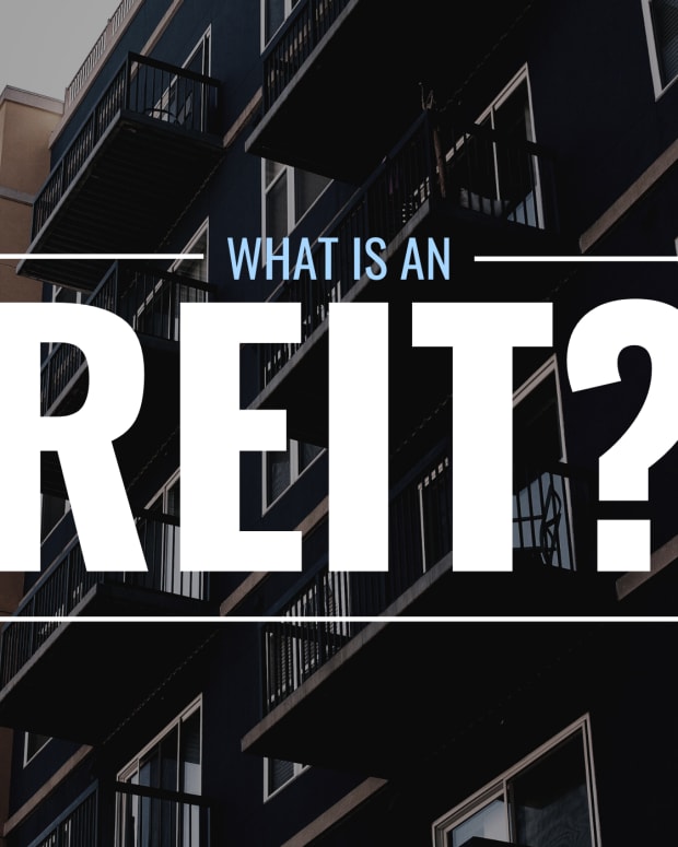 Darkened photo of an apartment complex from below with text overlay that reads "What Is an REIT?"