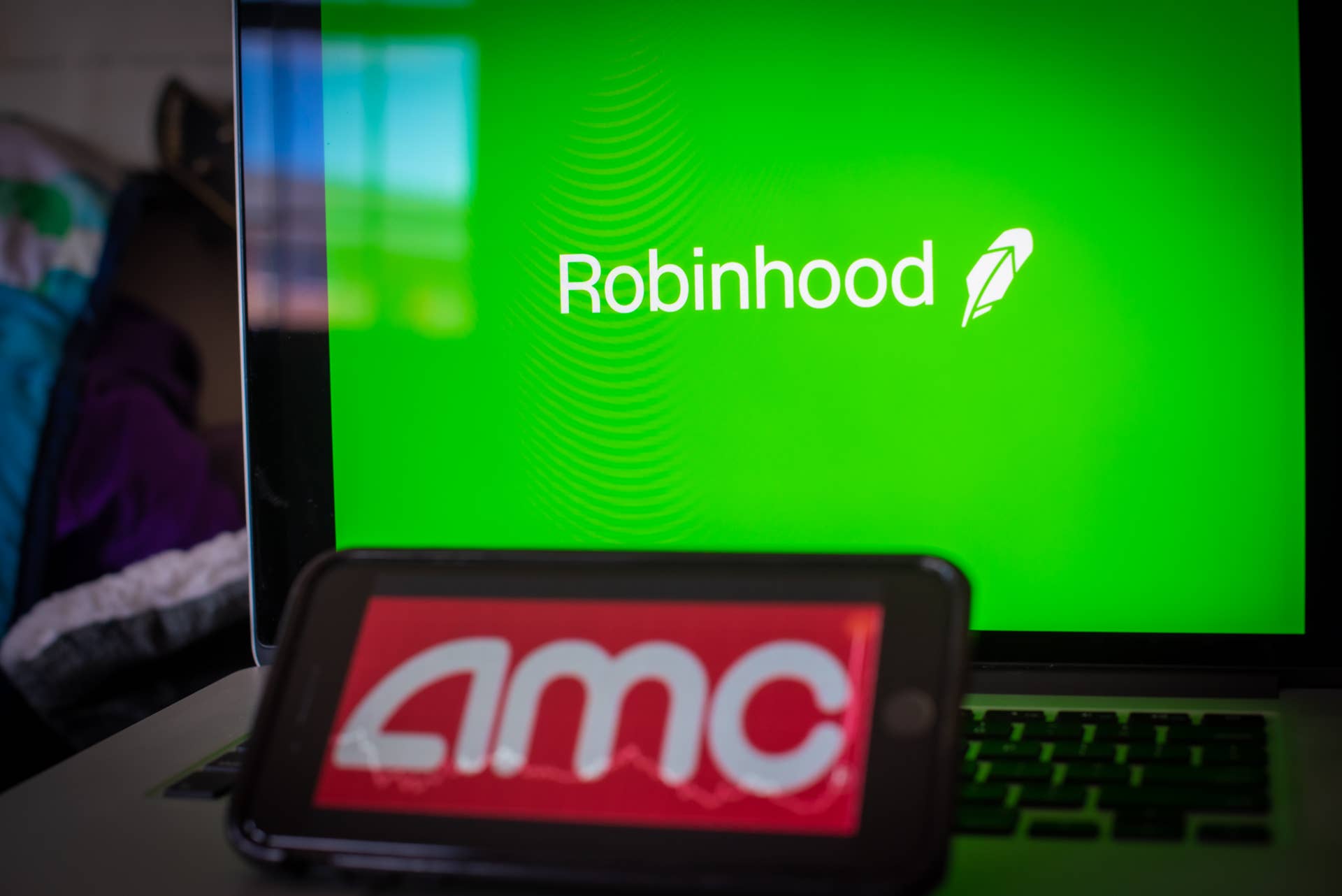 The AMC Entertainment Holdings Inc. logo on a smartphone and Robinhood logo on a laptop computer arranged in Hastings-On-Hudson, New York, U.S., on Friday, Jan. 29, 2021.