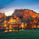 The spectacular 12-million-year-old boulder formations that dot the landscape at Boulders Resort &amp; Spa create a dramatic backdrop for performing your yoga poses. But don't let the rugged desert setting fool you: the resort provides true luxury with its newly renovated guest casitas and villas, two 18-hole championship golf courses, four swimming pools and 33,000-square-foot spa.Located about 30 miles north of Phoenix in Carefree, Ariz., Boulders offers an array of complimentary yoga classes for guests, which are taught both at the spa's yoga studio as well as in various outdoor settings. For instance, you can practice your "downward-facing dog" and "tree" poses in the resort's 5,600-square-foot organic garden, which features naturally flowing water, a reflection pond, raised planter boxes, citrus trees and an elevated teak platform for moonlight yoga classes. Or for an extra fee, you can take "Paddleboard Yoga," an hour-long yoga class taught at the spa's swimming pool for all levels. Participants stand on paddleboards while practicing yoga moves, which helps strengthen muscles while bringing peace of mind through the serenity of the water.If you'd like to book a stay, consider staying in a luxurious one-, two- or three-bedroom villa, which starts at $600 per night.