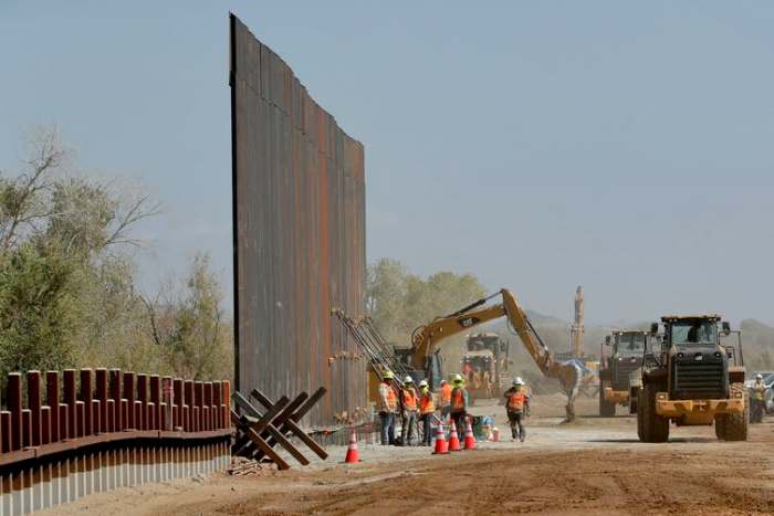 In this September 2019 photo, government contractors erect a section of the border wall along the Colorado River in Yuma, Ariz. (AP Photo/Matt York)