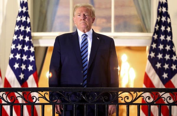 Trump stands, maskless, on the Truman Balcony after returning to the White House. Win McNamee/Getty Images)