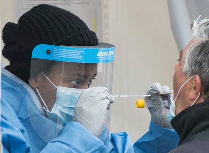 A health-care worker prepares to swab a man at a walk-in COVID-19 test clinic in Montreal North on May 10, 2020, as the COVID-19 pandemic continues in Canada and around the world. THE CANADIAN PRESS/Graham Hughes