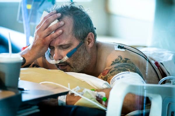 COVID-19 patient Michael Wright lay in his bed in the prone position to increase oxygenation. Wright died in December. Leila Navidi/Star Tribune via Getty Images