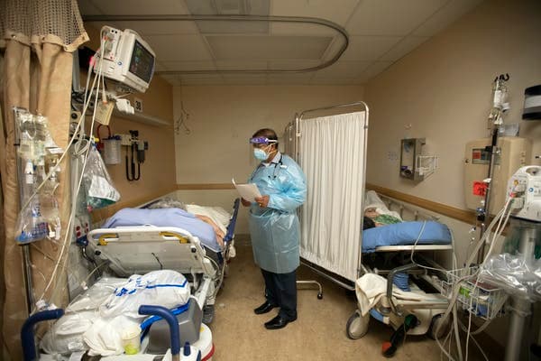 A doctor checks on patients in a temporary space at an overloaded hospital near Los Angeles. Francine Orr/Los Angeles Times via Getty Images