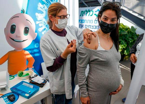 A health worker administers a dose of the Pfizer-BioNtech COVID-19 vaccine to a pregnant woman in Israel on Jan. 23. Jack Guez/AFP via Getty Images