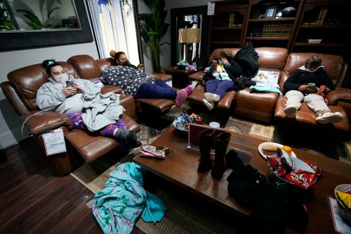 People with no power at their homes rest inside a Gallery Furniture store in Houston after the owner opened the business as a shelter on Feb. 16, 2021. AP Photo/David J. Phillip