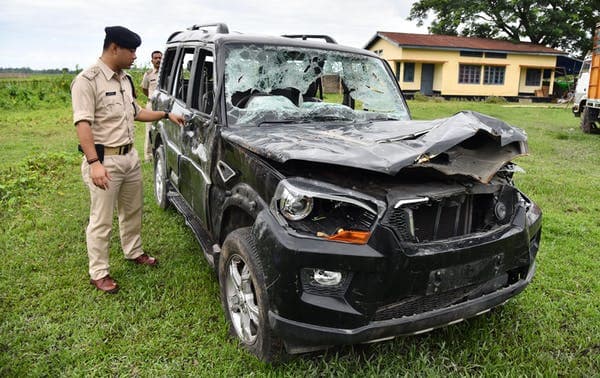 An Indian police officer inspects a damaged vehicle from which two men were taken and lynched by a mob afraid of strangers in their area because of misinformation spread on WhatsApp. Biju Boro/AFP via Getty Images