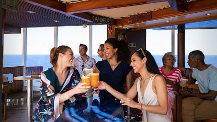People have a drink in a Carnival Cruise Bar Lead JS