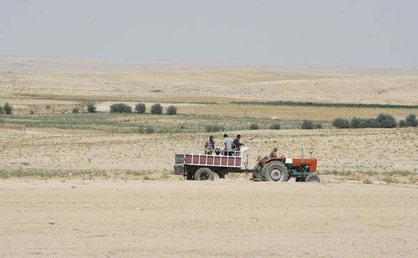 Farmers ride in a tractor in the drought-hit region of Hasaka, Syria, in 2010. Louai Beshara/AFP via Getty Images