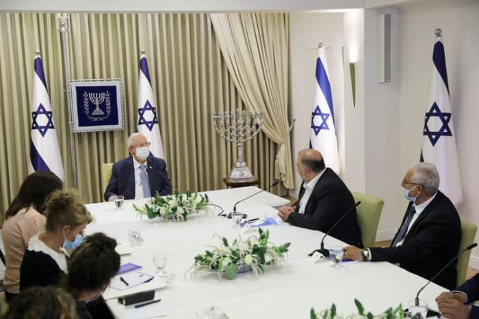 Mansour Abbas, leader of the Ra'am Party, second from right, and fellow Arab politician Mazen Ghanayem, right, discuss with Israeli President Reuven Rivlin who might form the next coalition government, at the president’s residence in Jerusalem on April 5, 2021. Abir Sultan/Pool Photo via AP