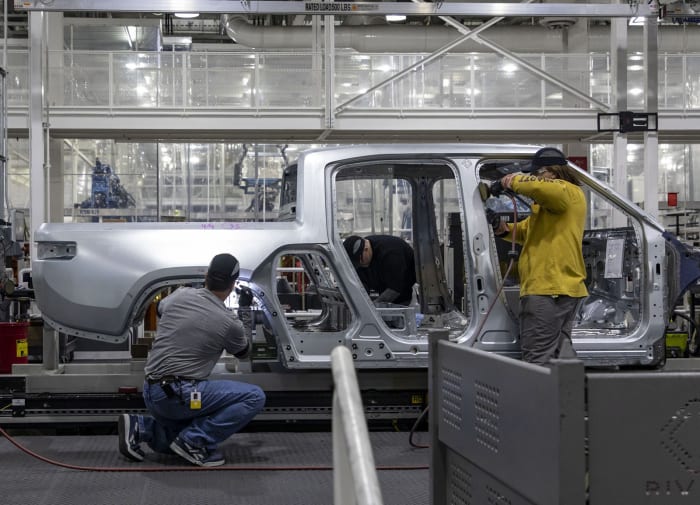 Workers assemble R1T trucks Monday, April 11, 2022, at the Rivian electric vehicle plant in Normal. (Brian Cassella/Chicago Tribune/Tribune News Service via Getty Images)