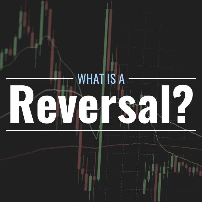 Obscured photo of a candlestick chart showing the volatile price action of an unknown asset with text overlay that reads: "What is a reversal?"