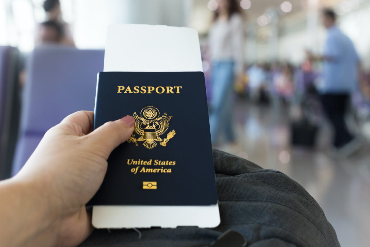 A person is seen holding a U.S. passport.