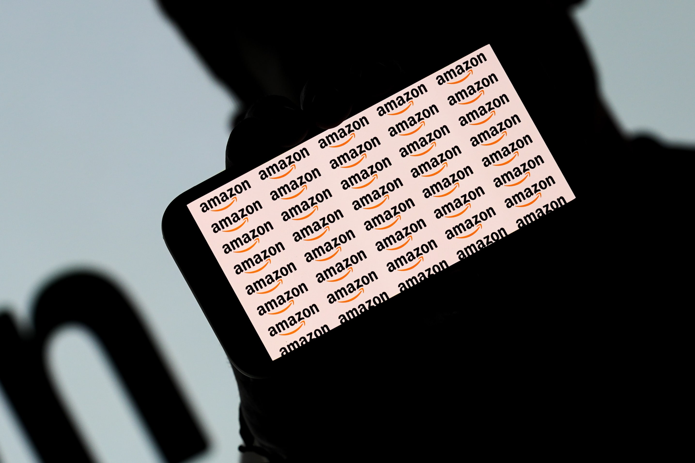 ANKARA, TURKIYE - JULY 4: In this photo illustration the Amazon icons is displayed on a mobile phone screen in front of the Amazon company logo in Ankara, Turkiye on July 4, 2024. (Photo by Dilara Irem Sancar/Anadolu via Getty Images)